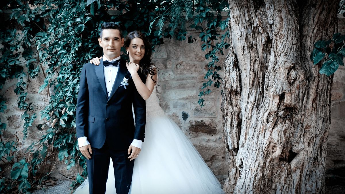 Sarmaşıklı taş duvar önünde gelin ve damat