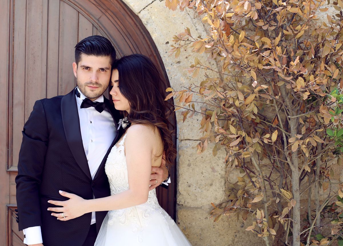 Ahşap kapı önünde sarılan gelin ve damat